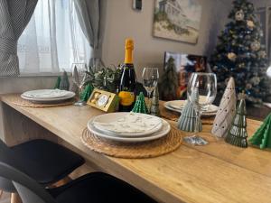 a table with plates and wine glasses and a christmas tree at Big Boss Caravan-Camber Sands,Sleep 8, Free Wi-Fi, Netflix, Parking in Camber