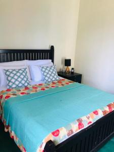 une chambre avec un lit avec une couette bleue dans l'établissement Rathkarawwa Heights, à Haputale