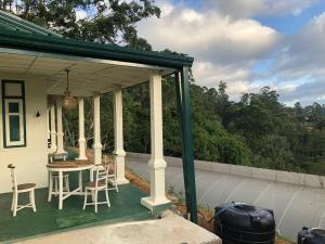 une terrasse avec une table et des chaises dans une maison dans l'établissement Rathkarawwa Heights, à Haputale