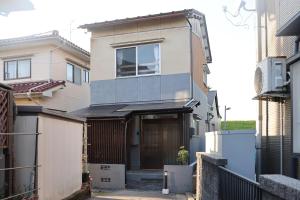 ein Haus mit einer Tür in einer Gasse in der Unterkunft くつろぎのお宿 やわや 駅北 in Toyama