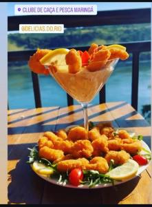 une assiette de nourriture avec des crevettes et du fromage sur une table dans l'établissement Casa ampla e aconchegante, à Foz do Iguaçu