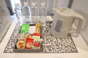 d'un grille-pain installé au-dessus d'un comptoir avec des bouteilles d'eau. dans l'établissement くつろぎのお宿 やわや 駅北, à Toyama