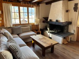 a living room with a couch and a fireplace at Chalet familial Rose de Noël in Les Diablerets