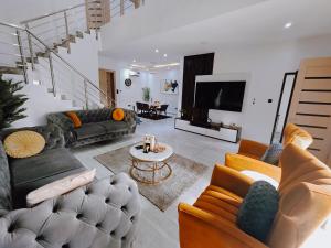 un salon avec des canapés, une table et une télévision dans l'établissement Bourdillon 3 Bedroom Luxury Apartment Ikoyi - 24hr Power, Wifi, Highly Secured, à Lagos