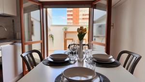 a dining room table with chairs and a table with glasses at Gioia's House in Montesilvano