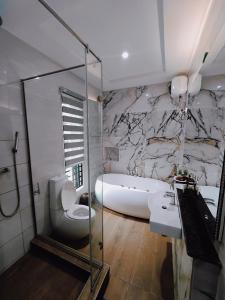 une salle de bain avec une baignoire, un lavabo et des toilettes dans l'établissement Bourdillon 3 Bedroom Luxury Apartment Ikoyi - 24hr Power, Wifi, Highly Secured, à Lagos
