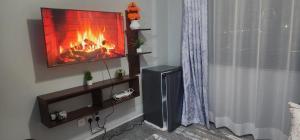 a living room with a fireplace and a tv at Fp&b apartments in Kisumu