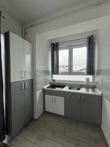 a kitchen with white cabinets and a sink and a window at db Home - Near Brasov City Center in Ghimbav +52 photos