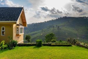 a house on a hill with a view of a mountain at Yellow Tulip Luxury Villa by LexStays - Coonoor in Kolakambe