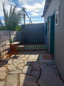 een stenen patio met een tafel en een hek bij Mooi Uitsig Droom in Beaufort West