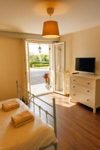 Gîte Chez Julie - Clima - Parking في سارلا لا كانيدا: غرفة نوم بسرير وتلفزيون وخزانة