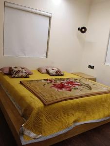 Una cama con manta amarilla y almohadas. en Vg paradise, en Covelong
