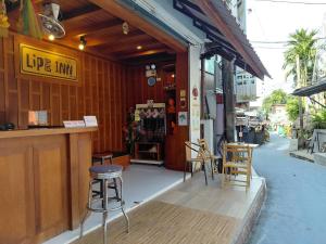 Un escaparate con taburetes y un bar en una calle. en Lipe Inn, en Ko Lipe