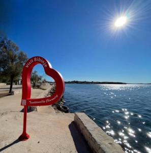 a red heart sign on the side of a body of water at Apartman Daria in Bibinje