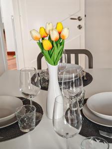 a table with wine glasses and a vase of flowers at Gioia's House in Montesilvano