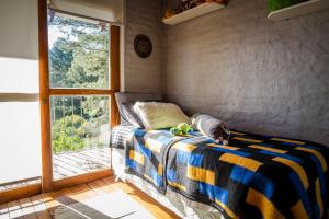 Y qué sea lo que sea في Balneario Ipora: غرفة نوم بسرير وبطانية مخططة ونافذة +20 صورة