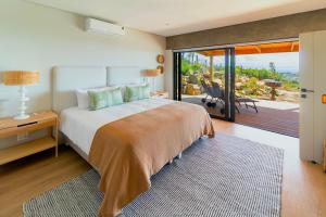 a bedroom with a large bed and a sliding glass door at StonenSea in Plettenberg Bay +14 photos