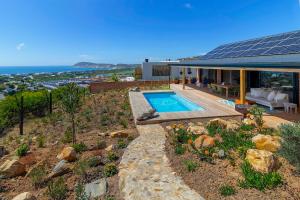 a house with a swimming pool on top of a hill at StonenSea in Plettenberg Bay
