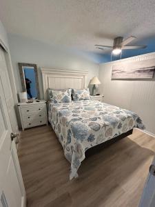 a bedroom with a bed and a dresser with a bedspread at Relax at the Beach in Myrtle Beach