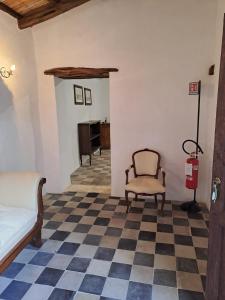 une chambre avec une chaise et un sol en damier dans l'établissement Foresteria di Villa Carboni, à Cagliari