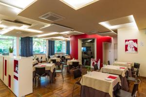 un restaurante con mesas y sillas blancas y paredes rojas en KaRe, en Banchette