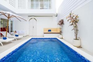 een zwembad in een woonkamer met witte muren en een wit huis bij Luxury minimalist villa The Toy in Kerobokan