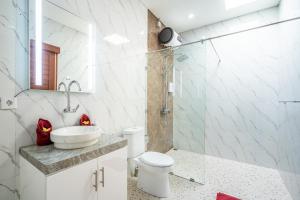 een badkamer met een toilet, een wastafel en een douche bij Luxury minimalist villa The Toy in Kerobokan +41 foto's