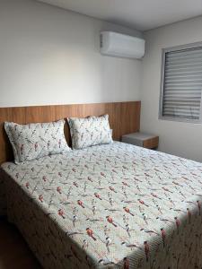 um quarto com uma cama com uma colcha em cima em Kitnet cobertura Centro Bom Despacho em Bom Despacho mais 15 fotografias