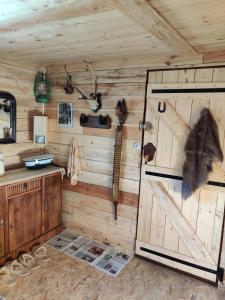 a room with a wooden wall with a door and tools at La Cabane du Trappeur in La Bourgonce