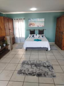 ein Schlafzimmer mit einem Bett und einem Teppich auf dem Boden in der Unterkunft Ocean Nook in Gqeberha