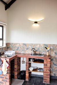 cocina con encimera de ladrillo y fregadero en Pecan and Lime Inn The Third Den, en Pretoria 2 fotos más