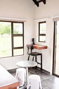 Una habitación con una mesa y sillas y ventanas. en Pecan and Lime Inn The Third Den, en Pretoria