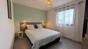 une chambre avec un lit et une fenêtre dans l'établissement Maison Amalia, à Sainte-Suzanne