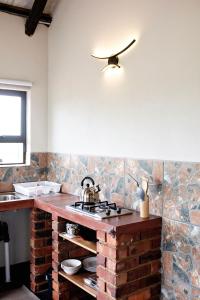 cocina con encimera de ladrillo y fregadero en Pecan and Lime Inn The Third Den, en Pretoria