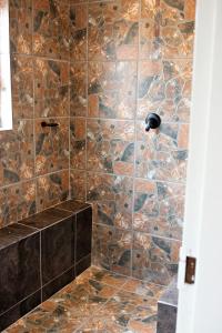 a bathroom with a stone shower with a stone wall at Pecan and Lime Inn The Third Den in Pretoria +2 photos