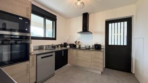 une cuisine avec un évier et une cuisinière four supérieur dans l'établissement Maison Amalia, à Sainte-Suzanne