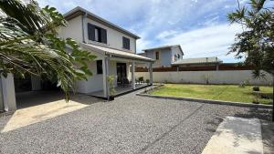une maison blanche avec une allée devant dans l'établissement Maison Amalia, à Sainte-Suzanne