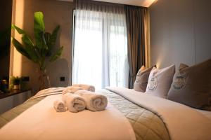 Un dormitorio con una cama con toallas. en KRUNA 406 Apartment, en Budva 50 fotos más