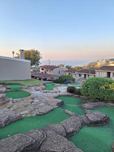 a golf course with rocks and green grass at Unit 40 Chakas Rock Chalets in Ballito