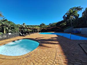 a large swimming pool on a brick patio at Unit 40 Chakas Rock Chalets in Ballito