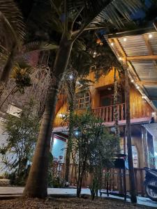 ein Haus mit Palmen davor in der Unterkunft La Cabaña del Tony in Villa Rica