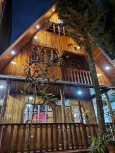 ein Holzhaus mit Bäumen davor in der Unterkunft La Cabaña del Tony in Villa Rica