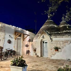 a white building with bikes parked outside at night at Trulli bella vite in Putignano