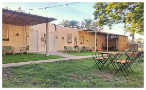 a patio with a table and chairs in a yard at סיאסטה בעמק - יחידות אירוח בקיבוץ 