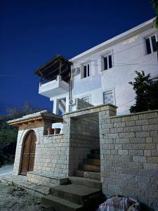 una casa blanca con una escalera al frente en Hotel Drasa, en Gjirokastra