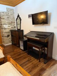 Un piano en una sala de estar con una habitación con en Hotel Drasa, en Gjirokastra