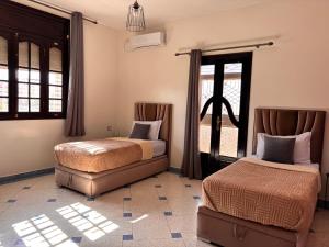 a bedroom with two beds and a window at Dar el kebira in Meknès +61 photos