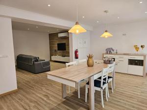 a kitchen and living room with a wooden table and chairs at Casa Trevo de 4 Folhas in Furnas