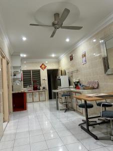 a kitchen with a ceiling fan and tables and chairs at Taman Gerik Homestay in Gerik