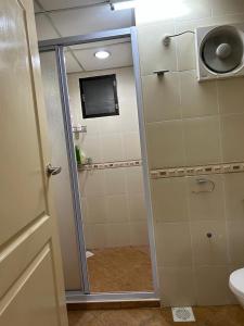 a bathroom with a shower with a sliding glass door at Taman Gerik Homestay in Gerik +4 photos